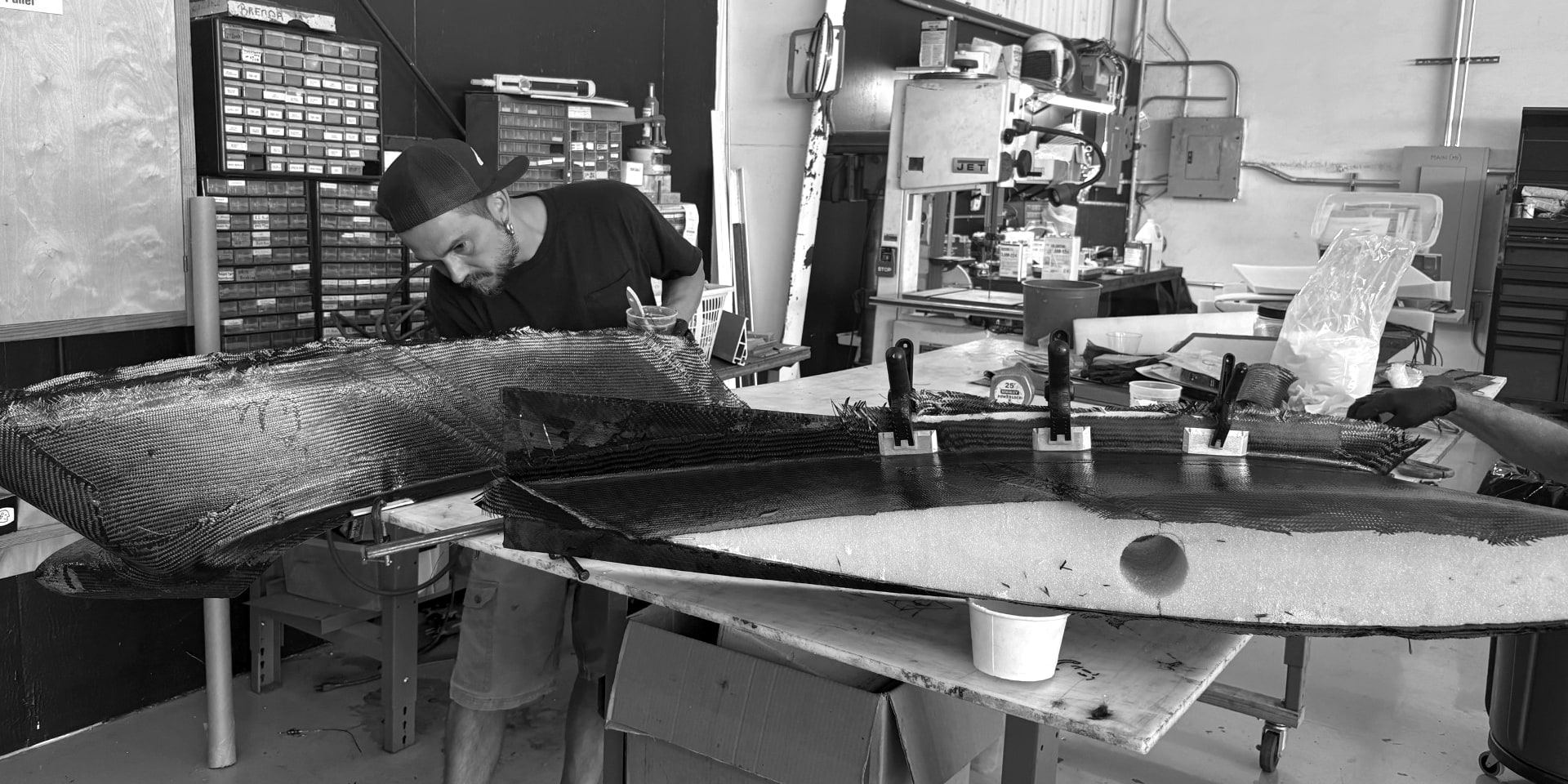 Technician laying up carbon fiber pylon halves on the bench in Fourth Front's Hangar 1 at Santa Monica Airport