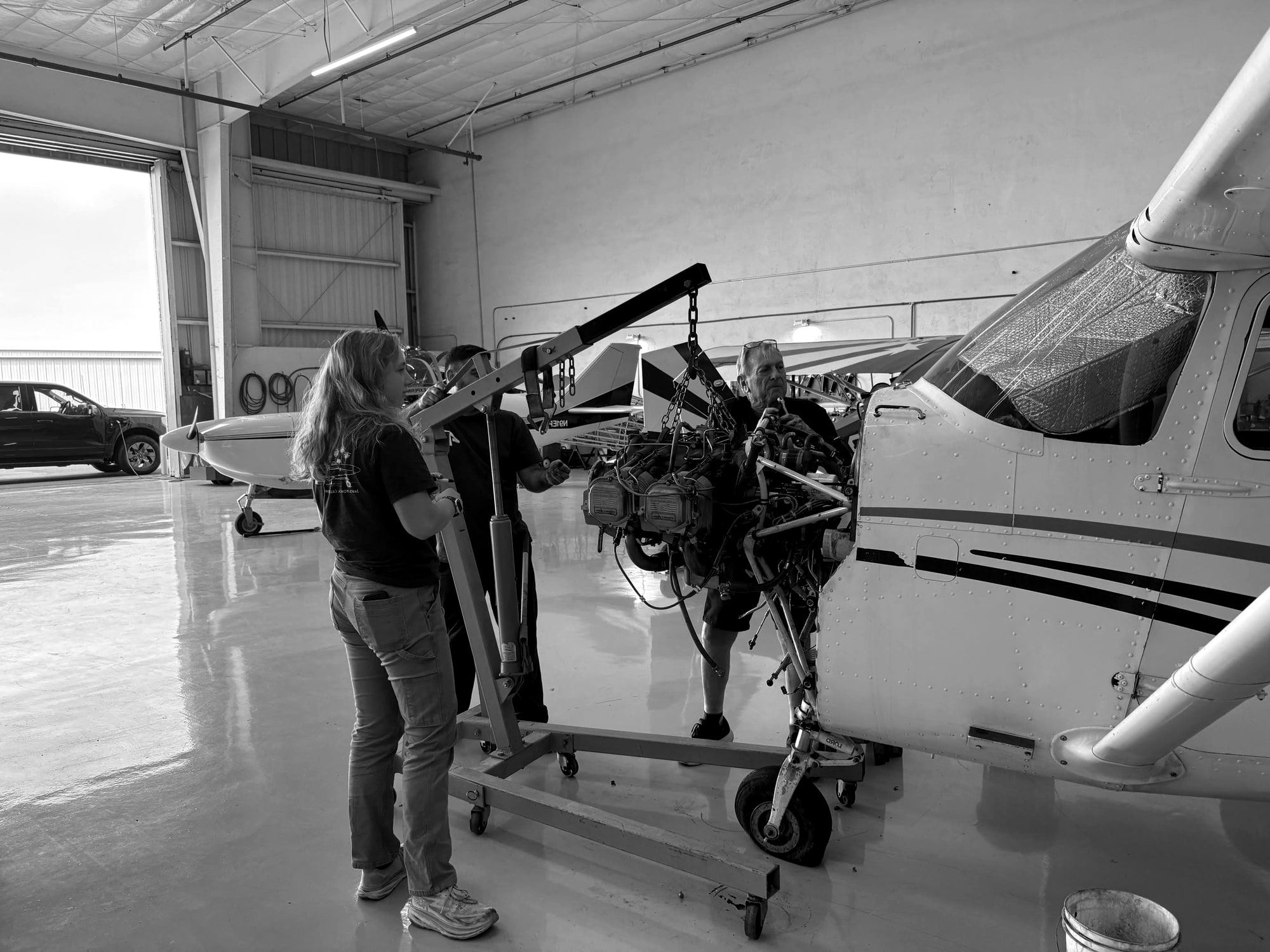 Fourth Front crew lifting an engine off a Cessna single with a hoist in Hangar 1 at Santa Monica Airport