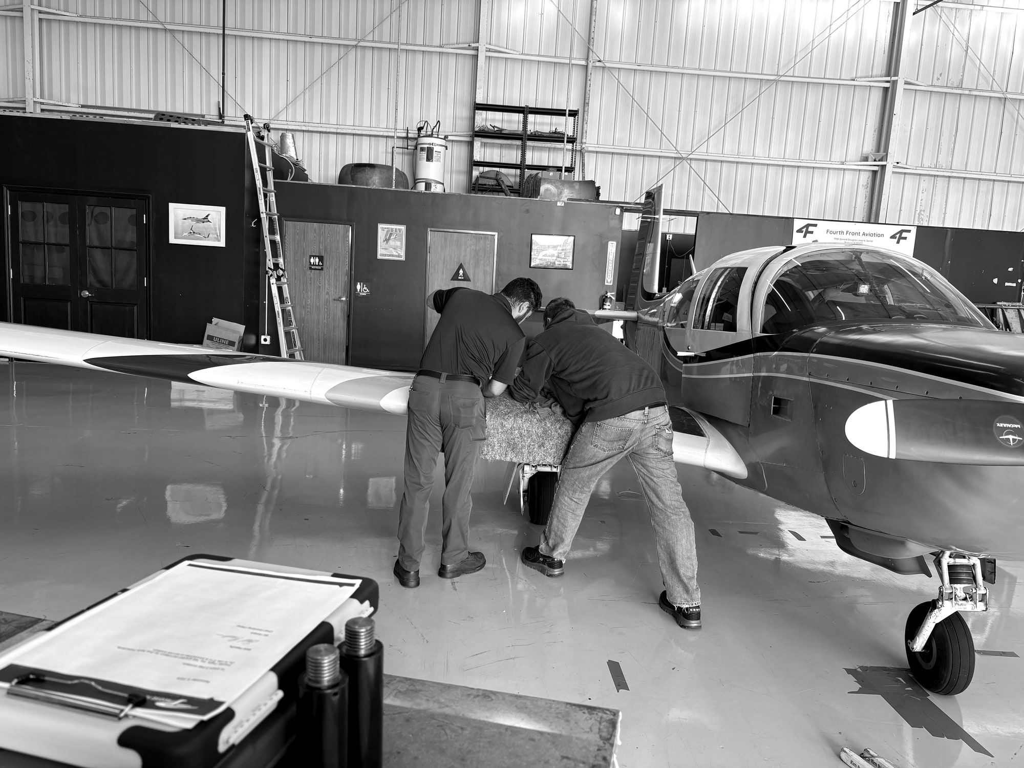 Fourth Front crew moving a twin through the hangar at Santa Monica Airport