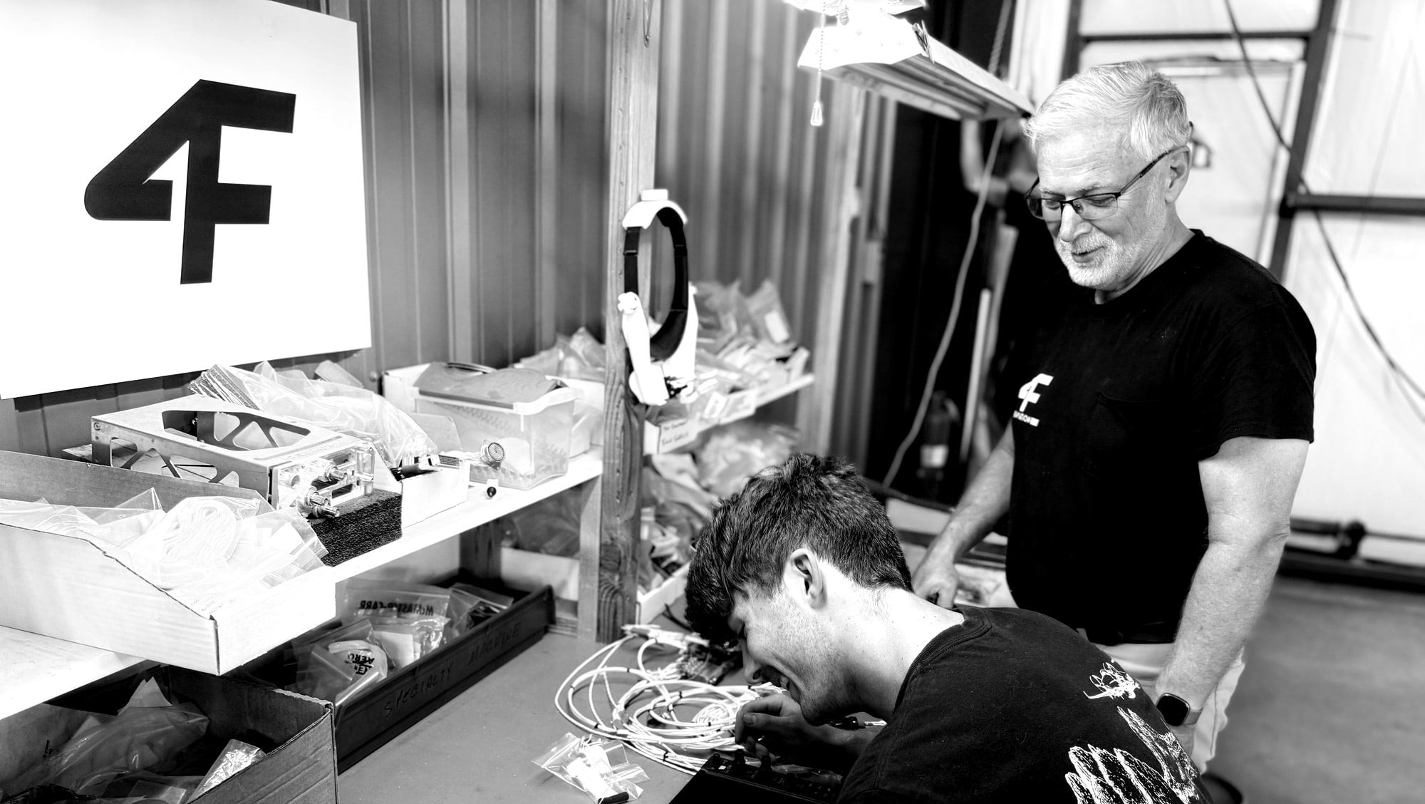 Two technicians at the Colorado Springs avionics bench working on a flight display