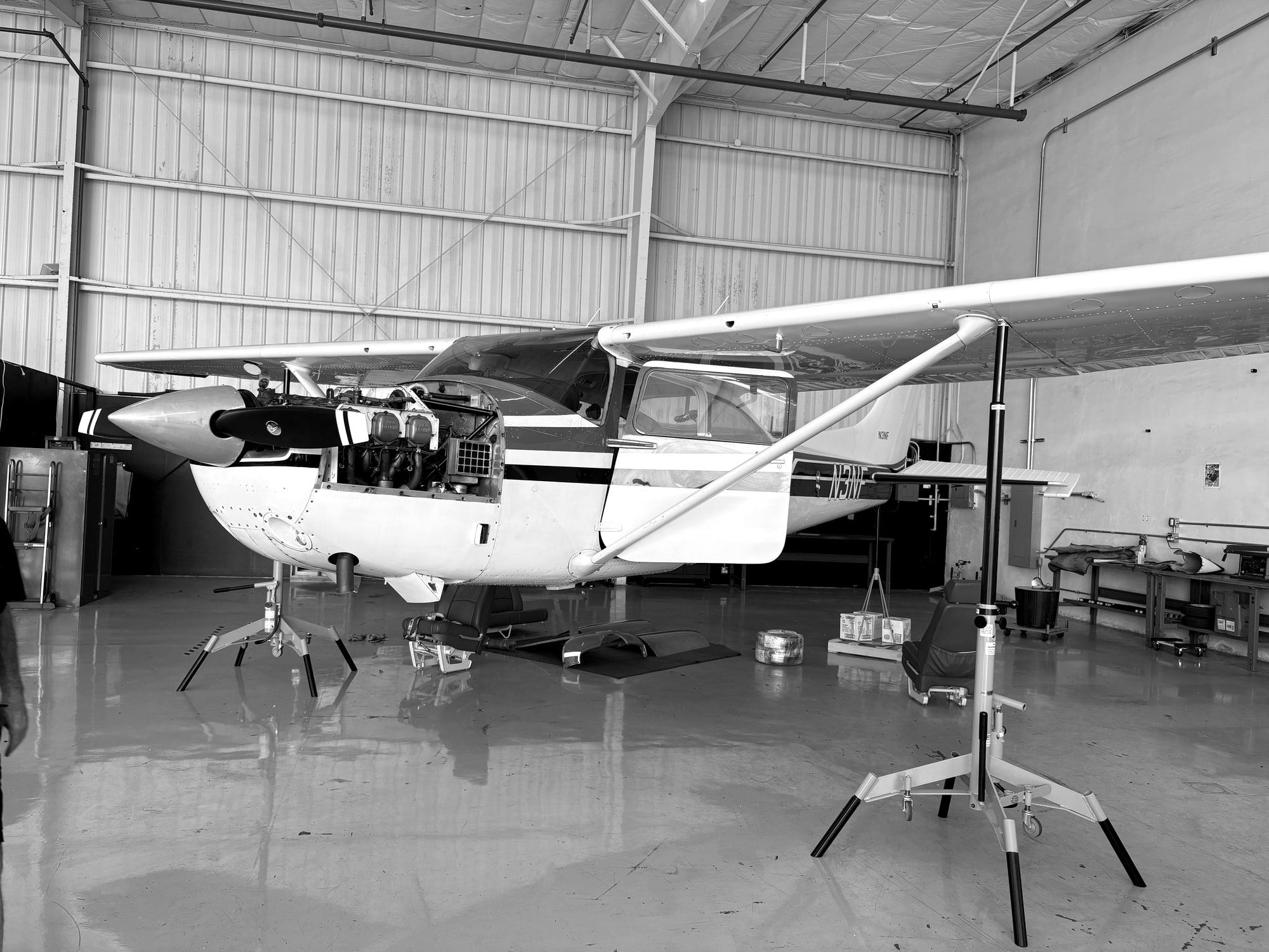 Cessna single on jacks with the cowling opened for an annual inspection in the Fourth Front hangar