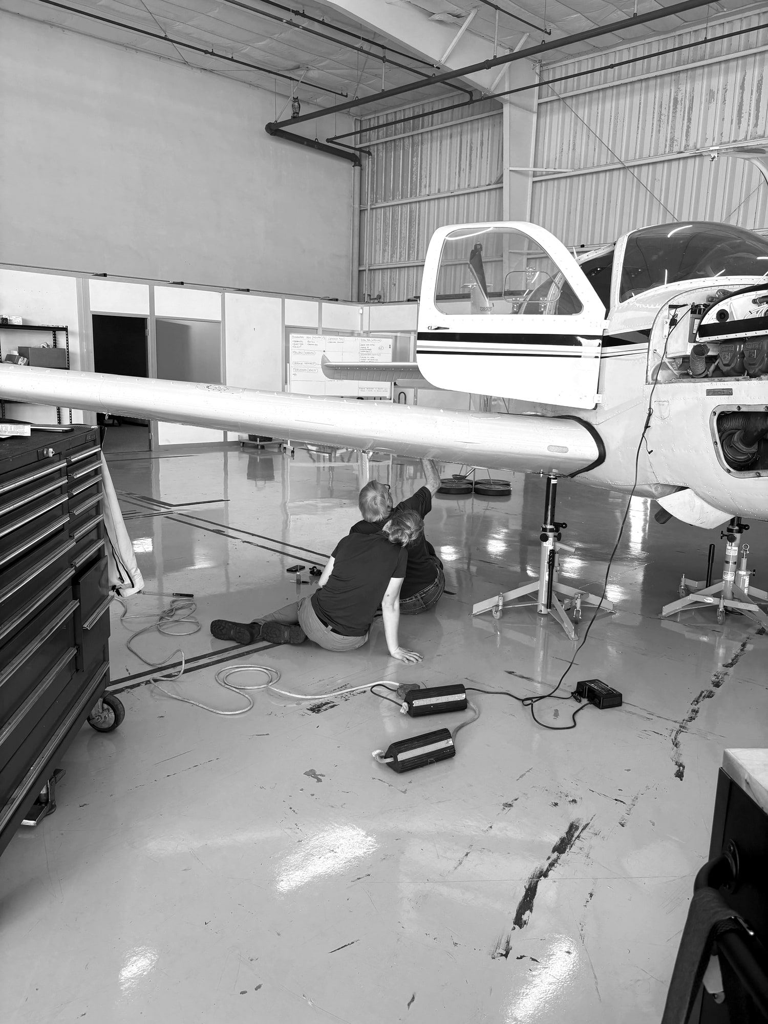 Technician inspecting the main landing gear under the wing of a twin at Santa Monica